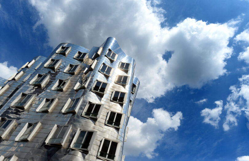 Zwischen Wolken ist der blaue Himmel über dem Gebäude B des Gebäudeensembles „Neuer Zollhof“ des Architekten Frank Gehry zu sehen. Der Star-Architekt Frank Gehry ist tot. Gehry sei im Alter von 96 Jahren nach einer kurzen Atemwegserkrankung in seinem Haus in Santa Monica gestorben, teilte seine Mitarbeiterin Meaghan Lloyd mit.