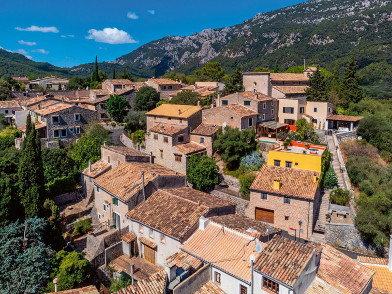 Auf dem Bild sind viele Häuser zu sehen. Es handelt sich um eine Luftaufnahme vom Gipfel eines Hügels in Bunyola, Mallorca