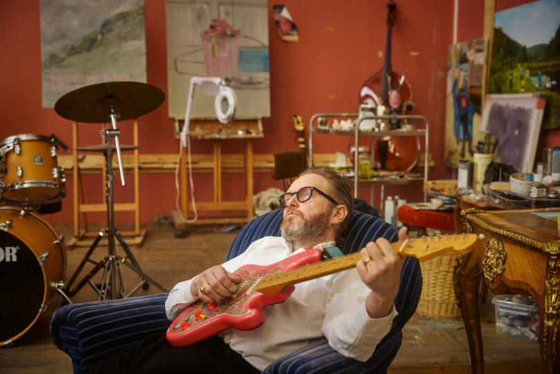 Kjartanssons Studio am alten Hafen von Reykjavík ist eine Mischung aus Maleratelier, Probenraum und Wohnzimmer. Hier liegt der Künstler auf einem Sessel und spielt Gitarre