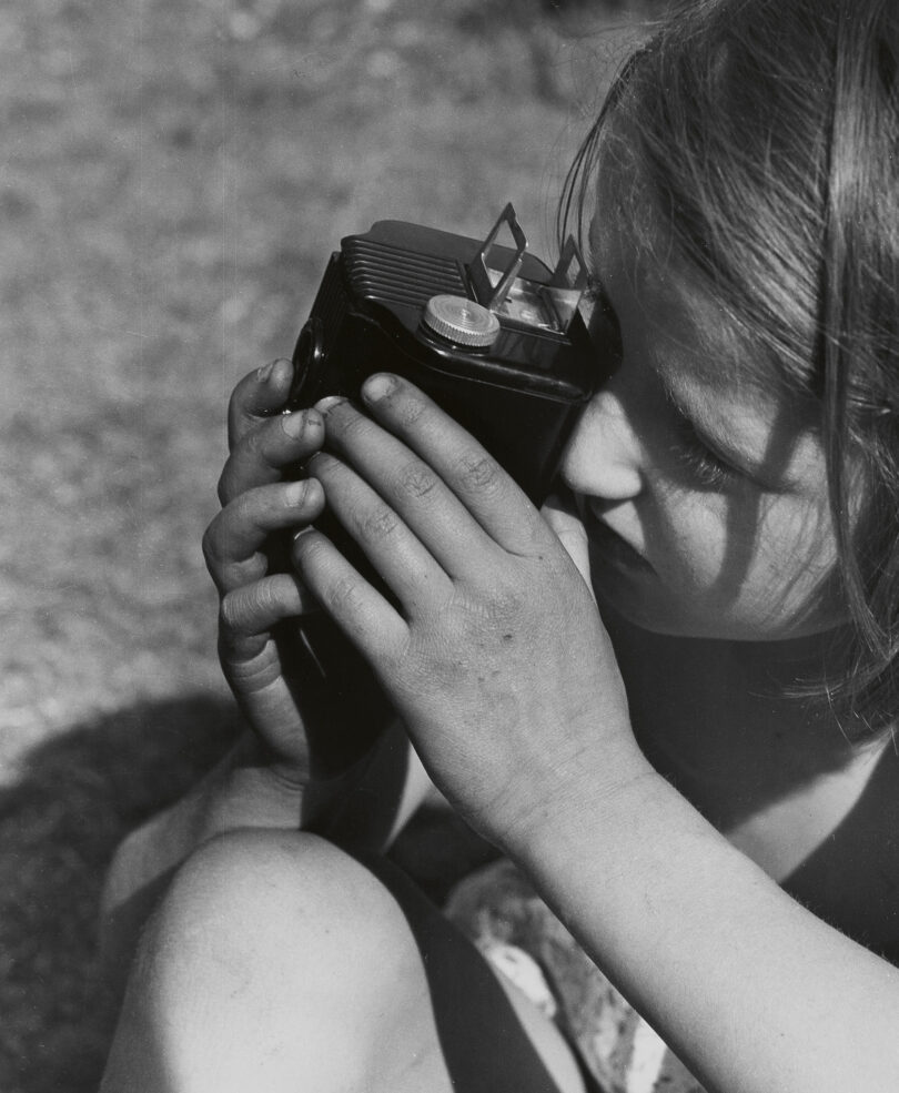 Porträt eines Mädchen beim Fotografieren mit einer Kamera