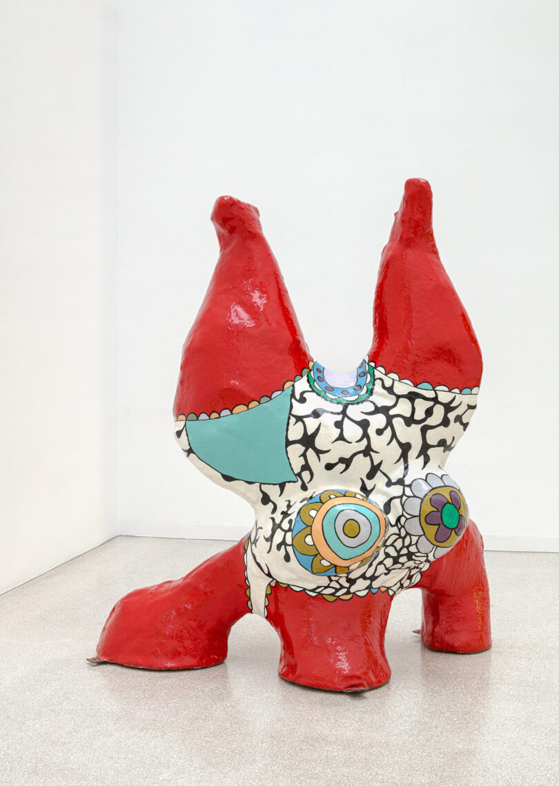 Frauenskulptur auf dem Kopf stehend in roter Farbe