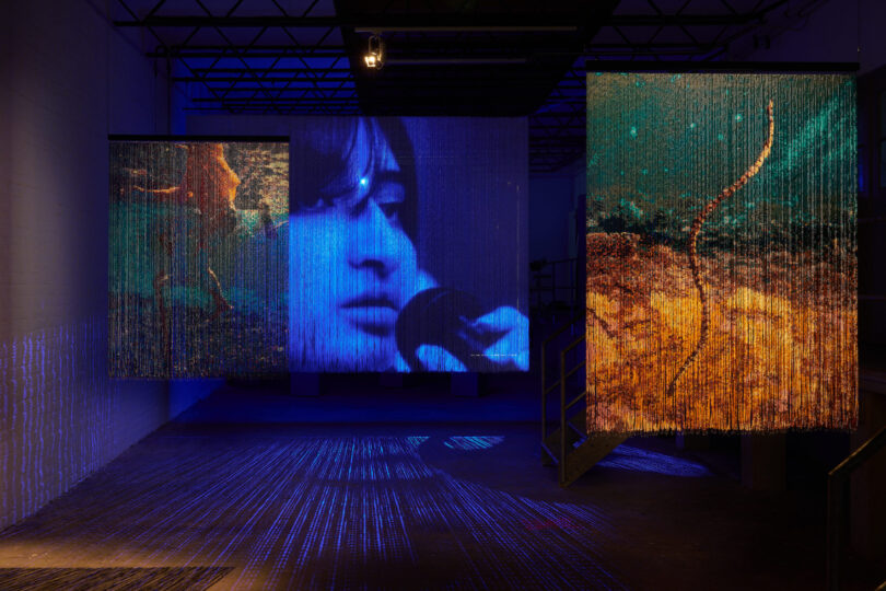Installationsansicht, Perlenvorhänge, blaue und orangene Lichter